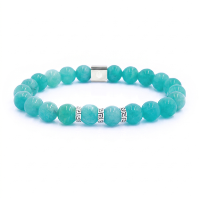 A beaded stretch bracelet made of round turquoise-blue gemstone beads, featuring two silver-tone metal beads with black Greek key patterns and a silver clasp, shown on a plain white background.