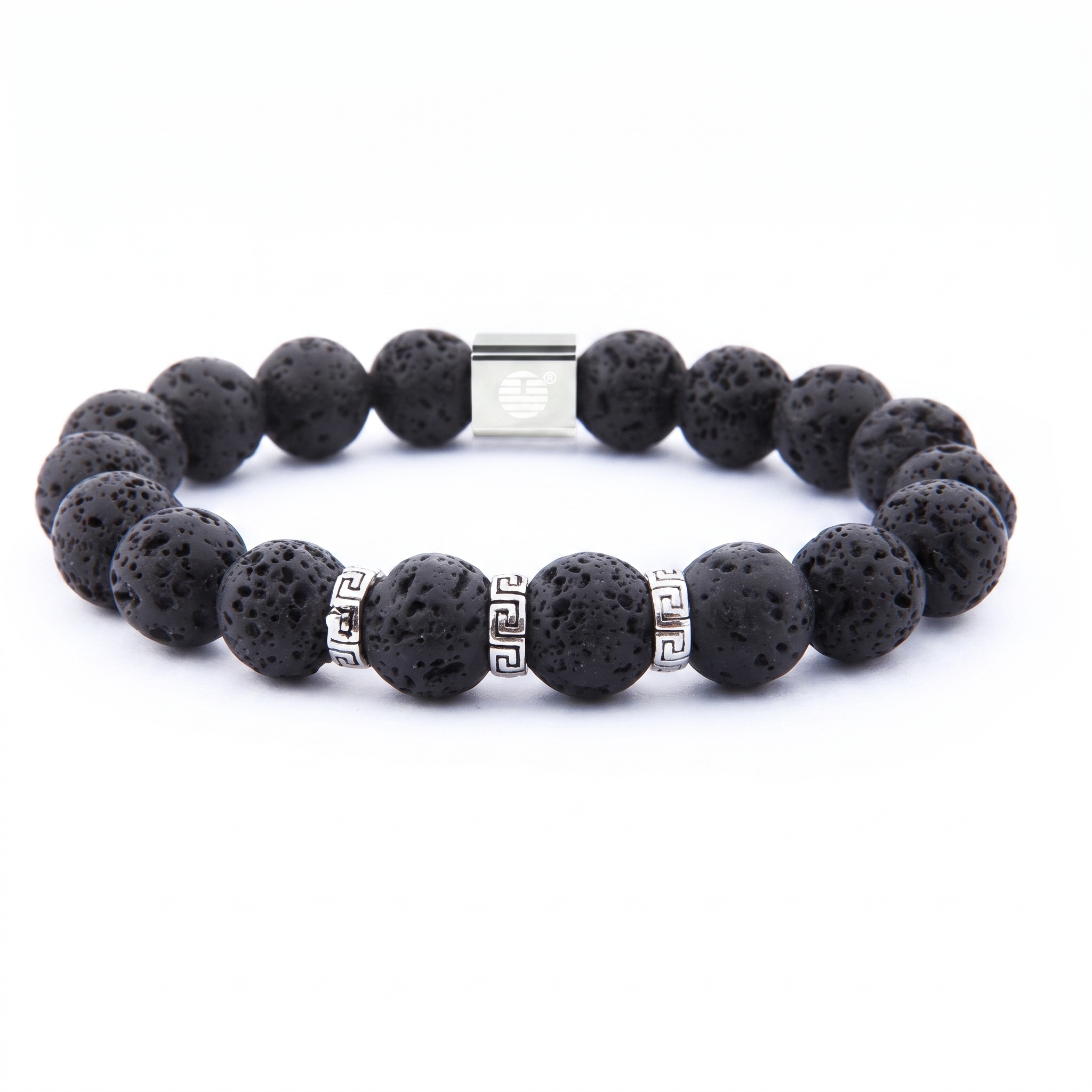 A beaded stretch bracelet made of black porous lava stone beads, accented with silver-tone spacer beads featuring a Greek key pattern and a rectangular silver clasp, shown on a plain white background.