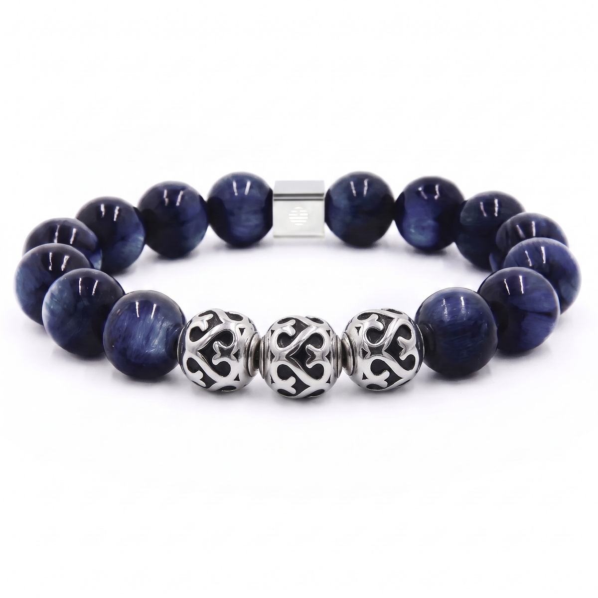 A beaded stretch bracelet featuring dark blue sapphire-like round beads, three silver filigree spacer beads, and a silver magnetic clasp, shown on a white background.