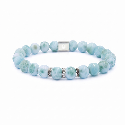 A beaded stretch bracelet made of light blue and green marbled round beads, accented by two silver Greek key beads and a silver magnetic clasp, shown on a white background.
