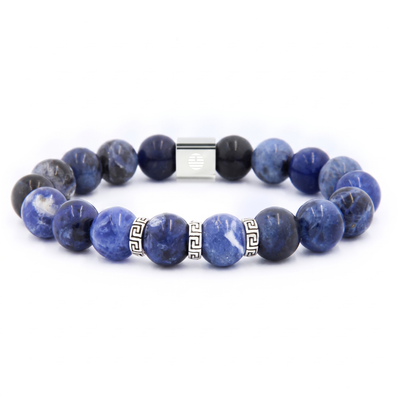 A beaded stretch bracelet made of polished blue and black sapphire-like beads, featuring a silver rectangular clasp and two silver Greek key spacer beads, shown on a white background.
