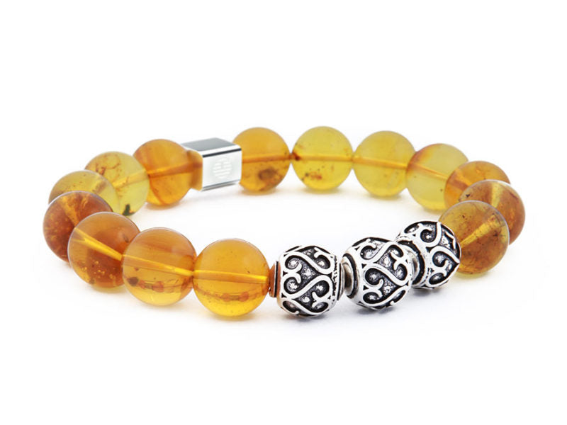 Amber beaded bracelet with silver clasp on a white background