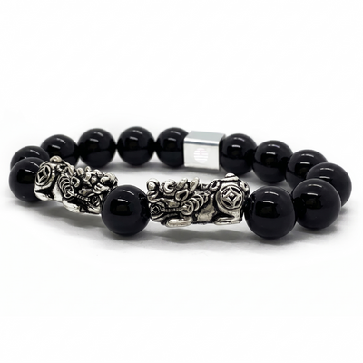 A beaded bracelet featuring glossy black round beads and ornate silver-toned metal charms, including a central lion and rose detail, set against a plain white background.